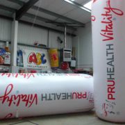 2 giant inflatable replica water bottles for PruHealth with man holding ropes