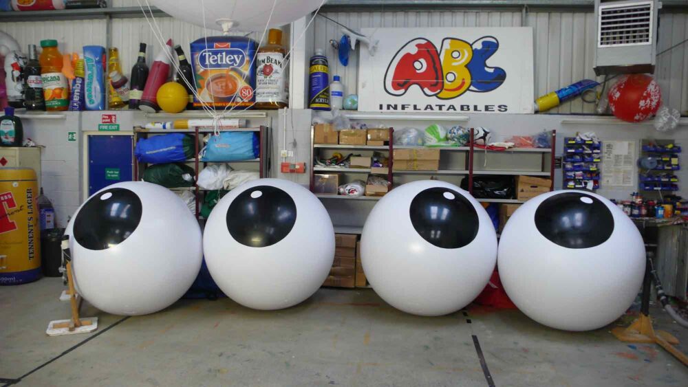 4 large white push balls with black circle containing white dots in ABC Inflatables workshop