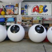 4 large white push balls with black circle containing white dots in ABC Inflatables workshop
